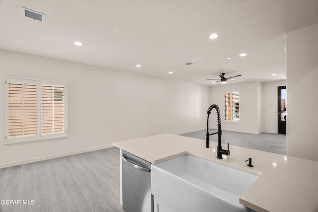 kitchen featuring stainless steel dishwasher, sink, light wood-type flooring, and ceiling fan