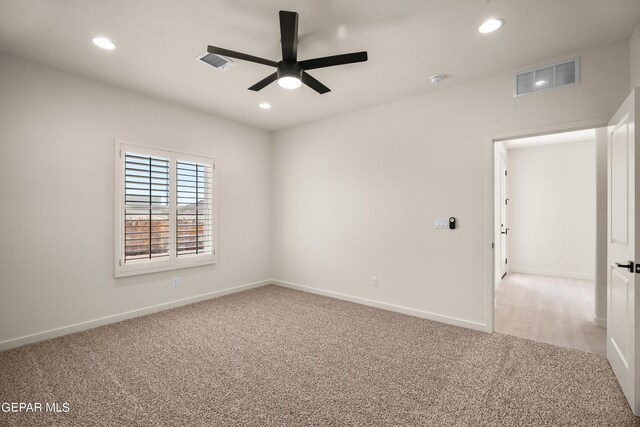 carpeted spare room featuring ceiling fan