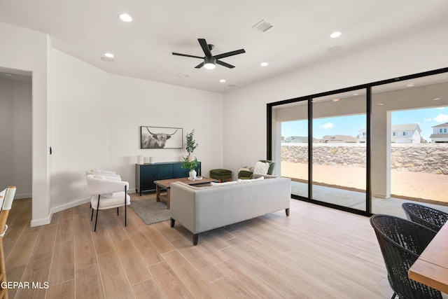 living room with light hardwood / wood-style floors and ceiling fan