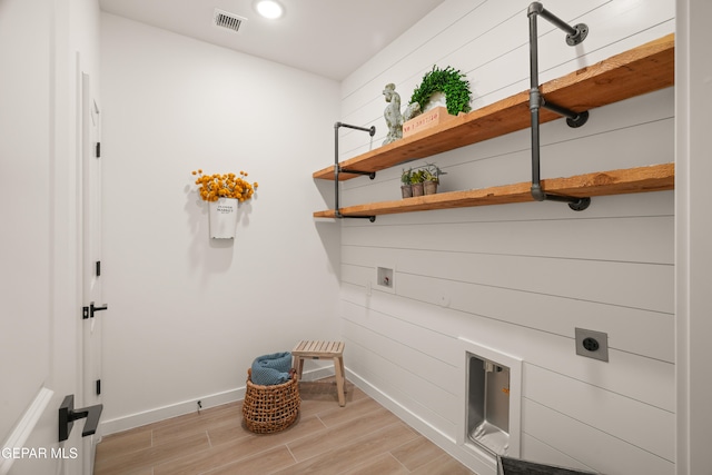 clothes washing area featuring hookup for an electric dryer, light hardwood / wood-style flooring, and washer hookup