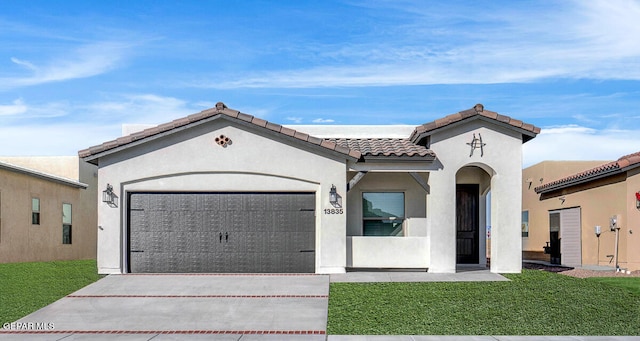 mediterranean / spanish home featuring a garage and a front lawn