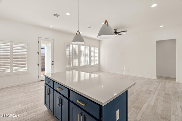 kitchen with light hardwood / wood-style floors, plenty of natural light, and a kitchen island