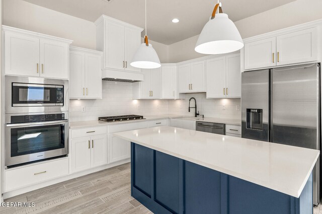 kitchen with decorative backsplash, white cabinets, decorative light fixtures, and stainless steel appliances