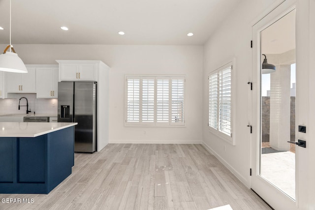 kitchen featuring hanging light fixtures, appliances with stainless steel finishes, plenty of natural light, and white cabinets