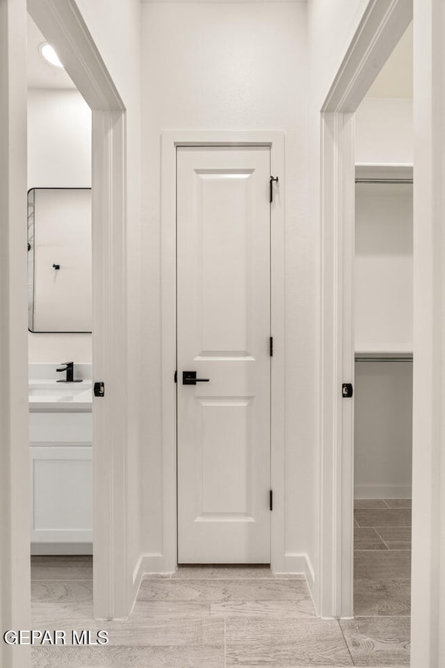 hallway featuring sink and light hardwood / wood-style flooring