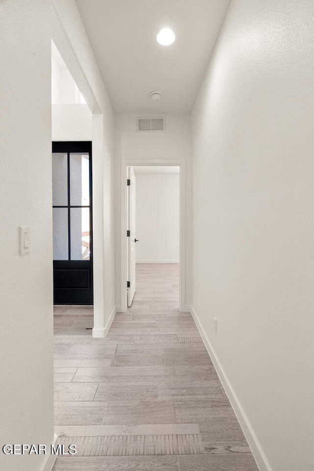 hallway with light hardwood / wood-style floors