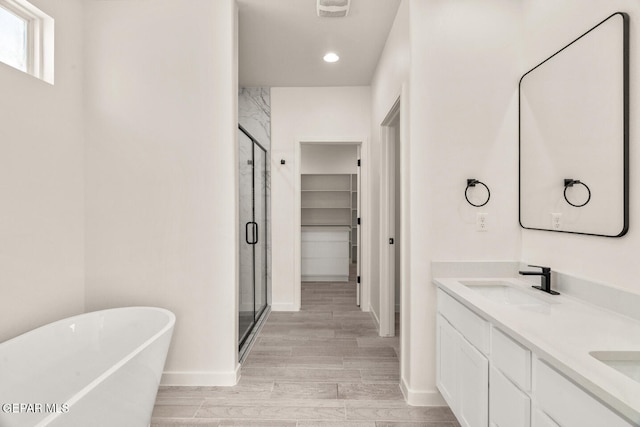 bathroom featuring vanity, plus walk in shower, and wood-type flooring