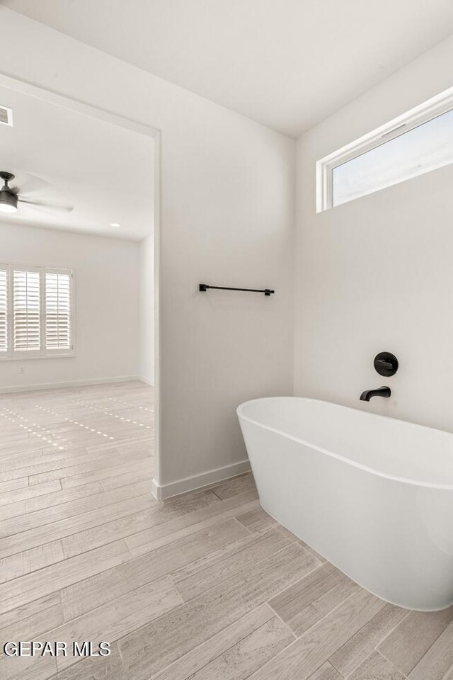 14960 Hill Ridge Ct, El Paso, TX 79938 - bathroom featuring a freestanding tub, a ceiling fan, wood finished floors, and baseboards