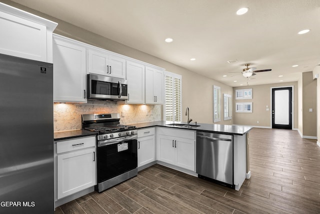 kitchen featuring sink, ceiling fan, stainless steel appliances, white cabinets, and dark wood-type flooring