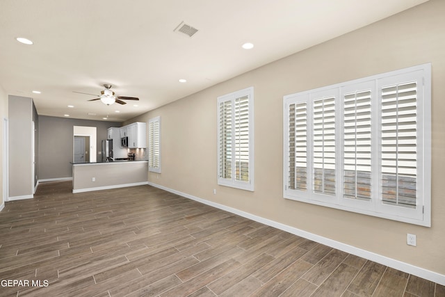 unfurnished living room with wood-type flooring and ceiling fan