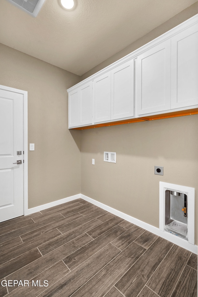 laundry area with dark wood-type flooring, washer hookup, cabinets, and hookup for an electric dryer