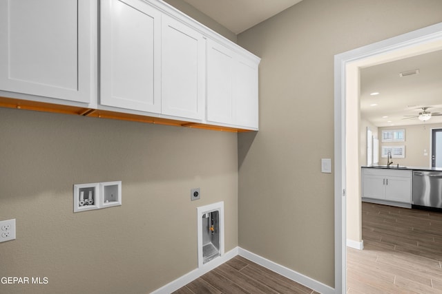 clothes washing area featuring hookup for an electric dryer, light wood-type flooring, sink, washer hookup, and cabinets