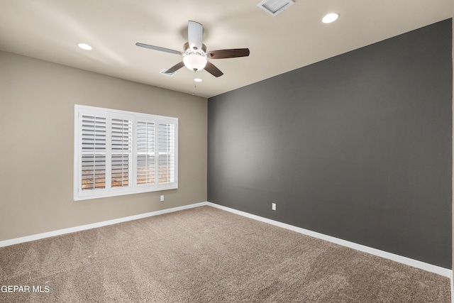 carpeted spare room featuring ceiling fan