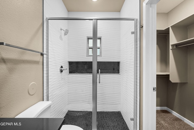 bathroom featuring toilet and walk in shower