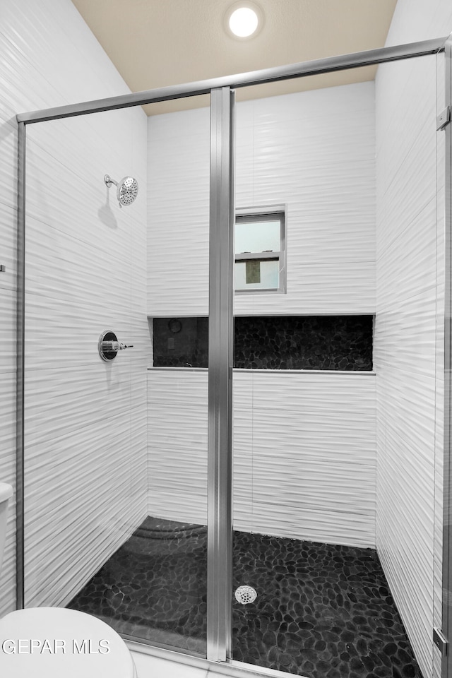 bathroom featuring toilet and an enclosed shower