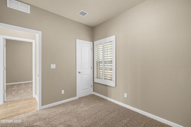 unfurnished bedroom with light colored carpet