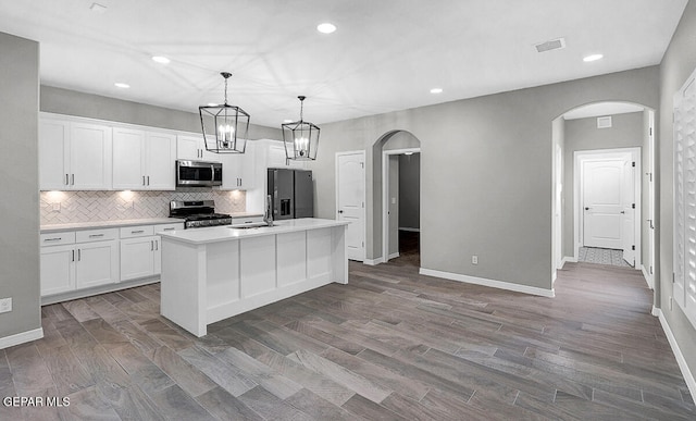 kitchen featuring white cabinetry, a kitchen island with sink, stainless steel appliances, and dark wood-type flooring