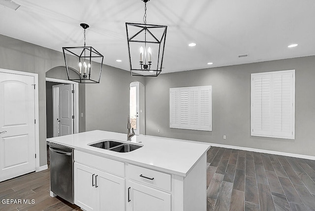 kitchen featuring a center island with sink, dark wood-type flooring, white cabinets, and decorative light fixtures