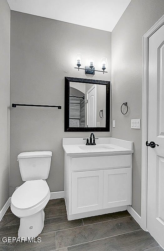 bathroom featuring vanity, hardwood / wood-style flooring, and toilet