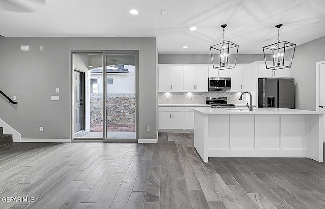 kitchen with sink, white cabinets, light hardwood / wood-style flooring, and stainless steel appliances