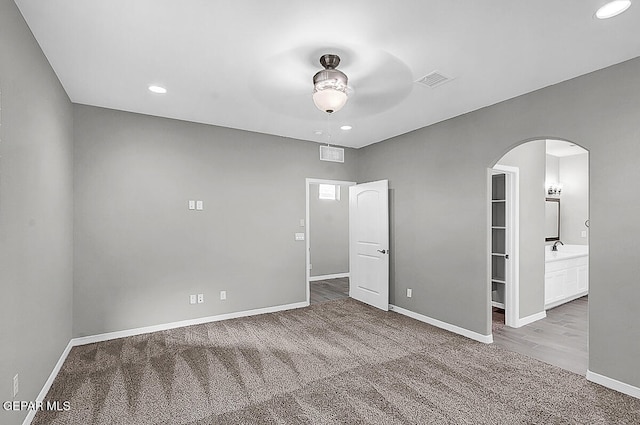 carpeted spare room with sink and ceiling fan