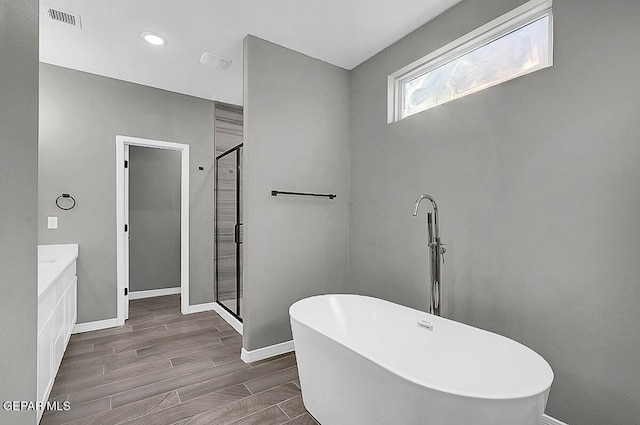 bathroom featuring vanity, separate shower and tub, and hardwood / wood-style floors