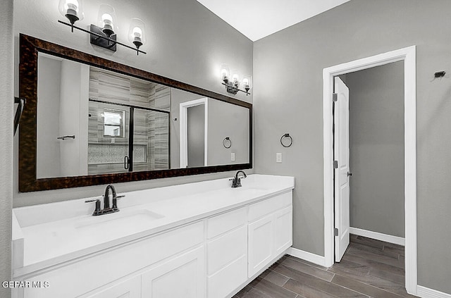 bathroom with vanity, hardwood / wood-style flooring, and a shower with shower door