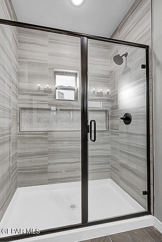 bathroom with a shower with door