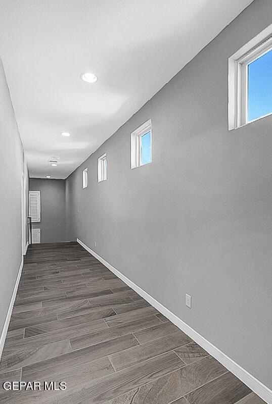 basement with dark hardwood / wood-style floors and a healthy amount of sunlight