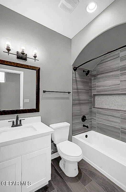 full bathroom with vanity, toilet, tiled shower / bath combo, and wood-type flooring