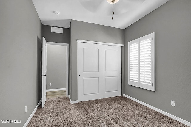 unfurnished bedroom with a closet, ceiling fan, and carpet floors