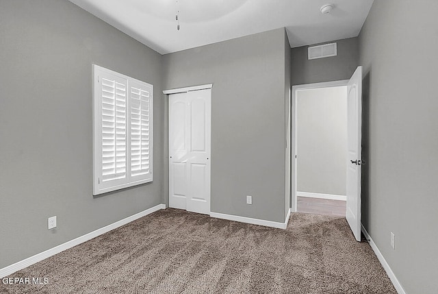 unfurnished bedroom with a closet, ceiling fan, and carpet floors