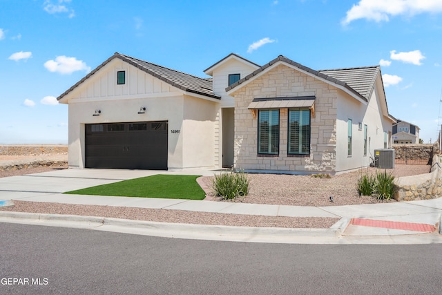 view of front of home with central AC and a garage