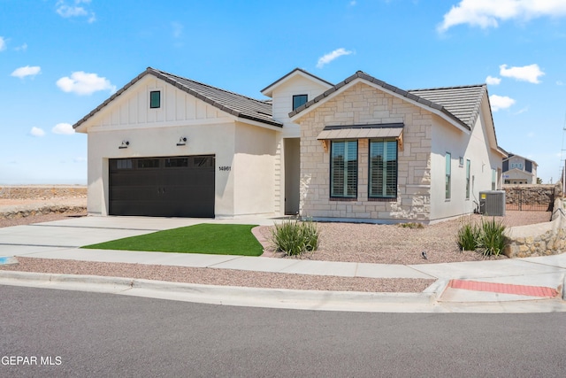 14956 Hill Ridge Ct, El Paso, TX 79938 - modern farmhouse featuring stone siding, an attached garage, concrete driveway, board and batten siding, and central AC