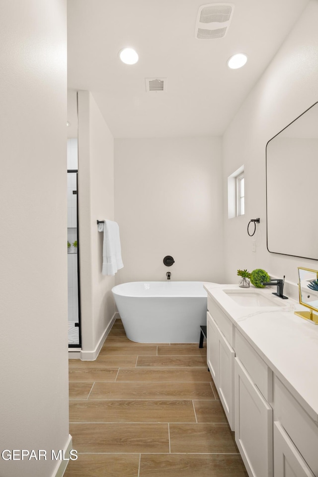 14956 Hill Ridge Ct, El Paso, TX 79938 - full bath featuring vanity, a soaking tub, wood finish floors, recessed lighting, and baseboards