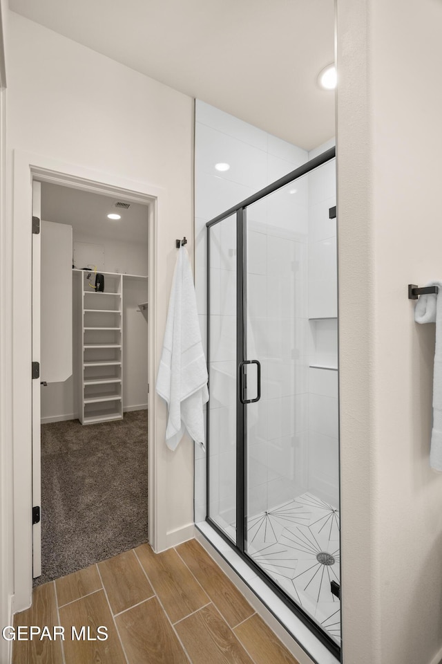 14956 Hill Ridge Ct, El Paso, TX 79938 - bathroom featuring a spacious closet, a stall shower, wood tiled floors, and recessed lighting
