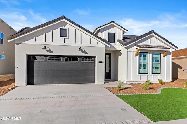 14952 Hill Ridge Ct, El Paso, TX 79938 - view of front of home featuring board and batten siding, concrete driveway, a garage, and a front yard
