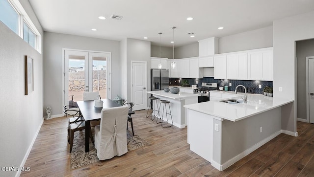 14953 Concept Ct, El Paso, TX 79938 - kitchen with stainless steel appliances, a kitchen breakfast bar, tasteful backsplash, wood finished floors, and light countertops