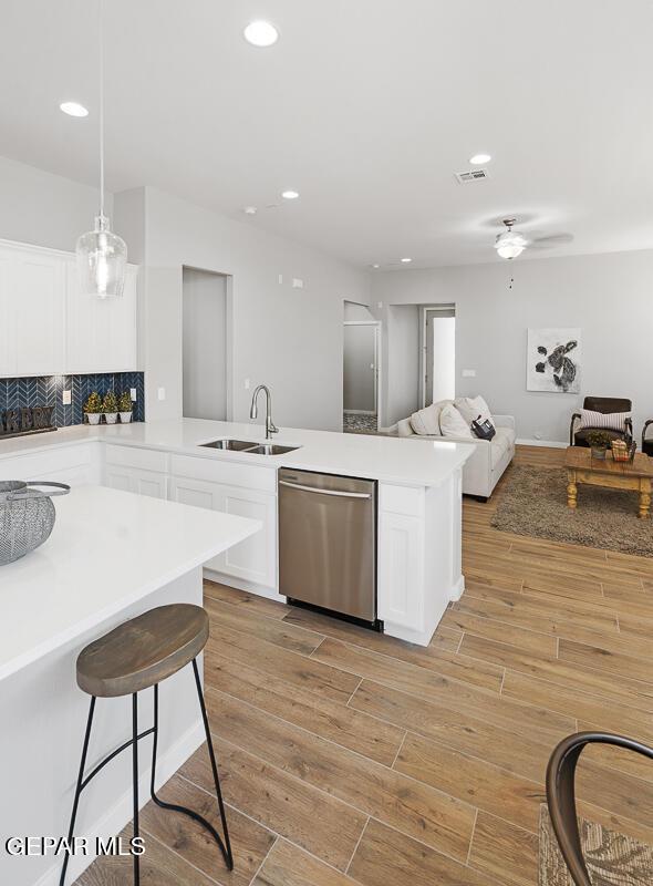 14953 Concept Ct, El Paso, TX 79938 - kitchen with stainless steel dishwasher, a peninsula, white cabinetry, light wood-style floors, and recessed lighting
