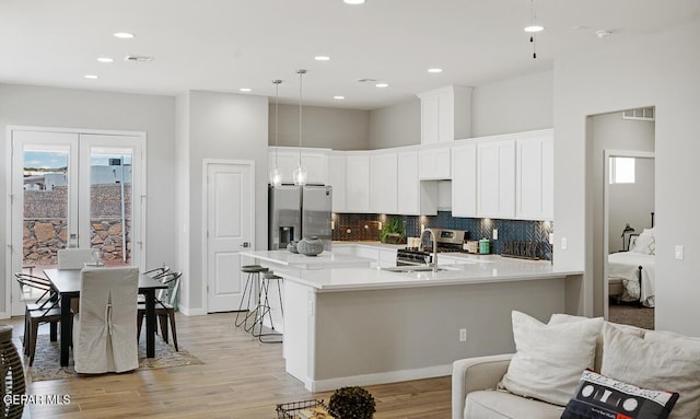 14953 Concept Ct, El Paso, TX 79938 - kitchen featuring appliances with stainless steel finishes, a kitchen bar, tasteful backsplash, light countertops, and recessed lighting