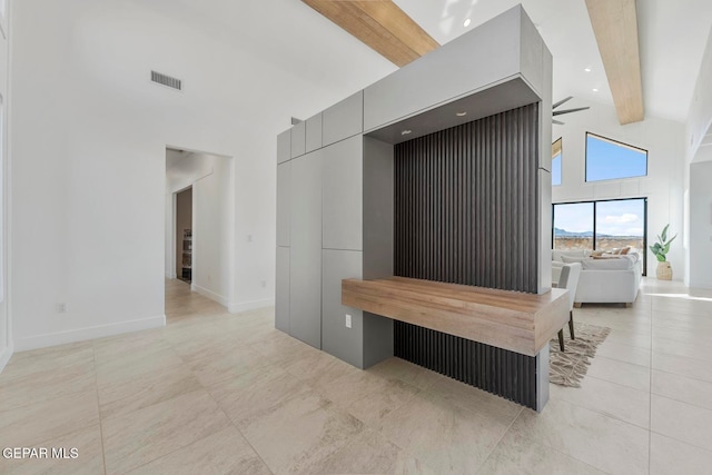 interior space featuring beam ceiling, light tile patterned floors, and high vaulted ceiling