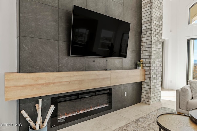 living room with light tile patterned flooring, tile walls, and a tiled fireplace