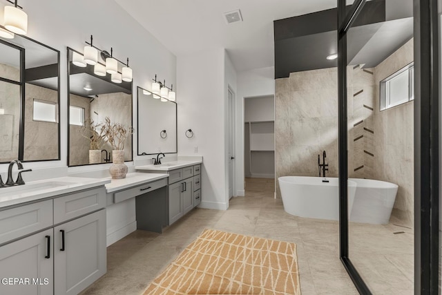 bathroom featuring a bathing tub, vanity, and a healthy amount of sunlight