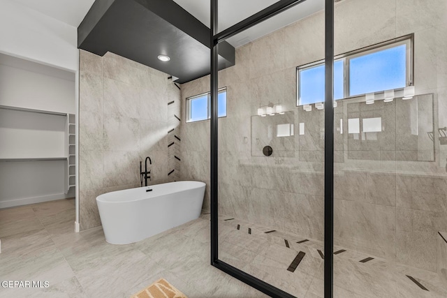 bathroom featuring tile walls and independent shower and bath