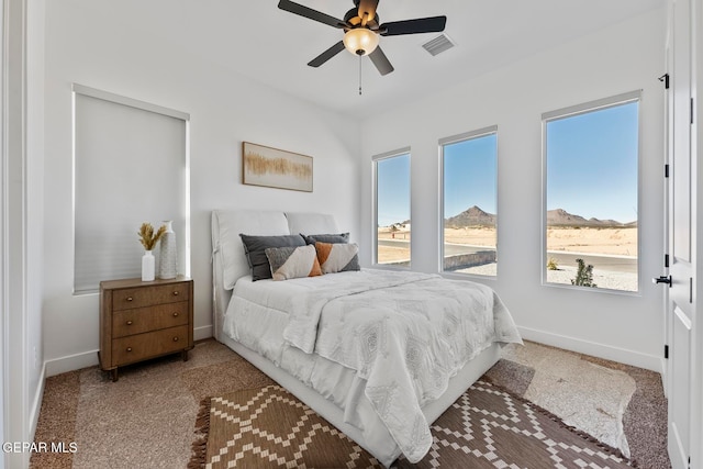 bedroom featuring ceiling fan, carpet floors, and a mountain view