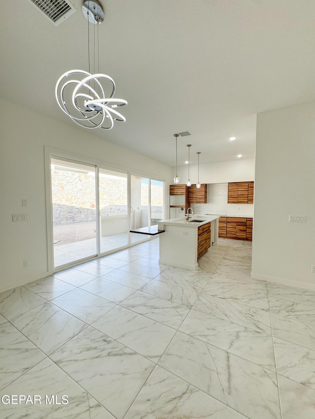 1783 Urijah Pl, El Paso, TX 79928 - kitchen featuring a sink, light marble finish flooring, light countertops, brown cabinets, and a chandelier