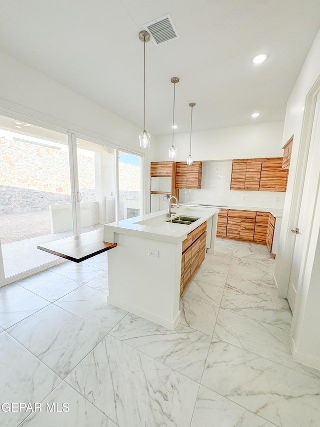 1783 Urijah Pl, El Paso, TX 79928 - kitchen featuring a sink, light marble finish flooring, brown cabinets, light countertops, and recessed lighting