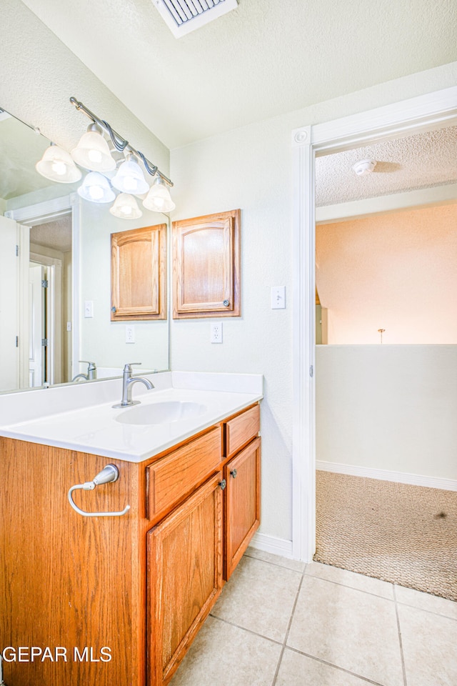 bathroom featuring vanity, a textured ceiling, and tile patterned flooring