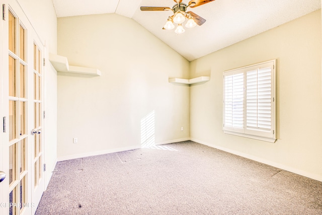 carpeted spare room featuring vaulted ceiling and ceiling fan