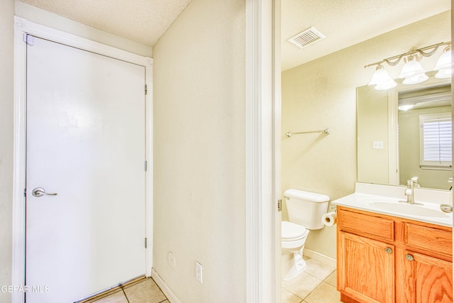 bathroom featuring toilet, a textured ceiling, vanity, and tile patterned flooring